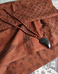 Artisan-made Dola silk saree featuring traditional Dhar Bagh wooden block prints with red and black floral motifs and Brownish red accents.