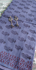 Handmade Purple fabric with Bagh print with  black patterns and silver earrings on a patterned surface