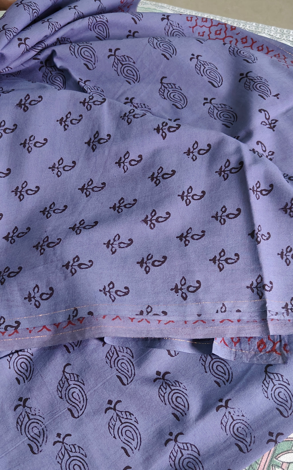 Handmade Purple fabric with Bagh print with  black patterns and silver earrings on a patterned surface