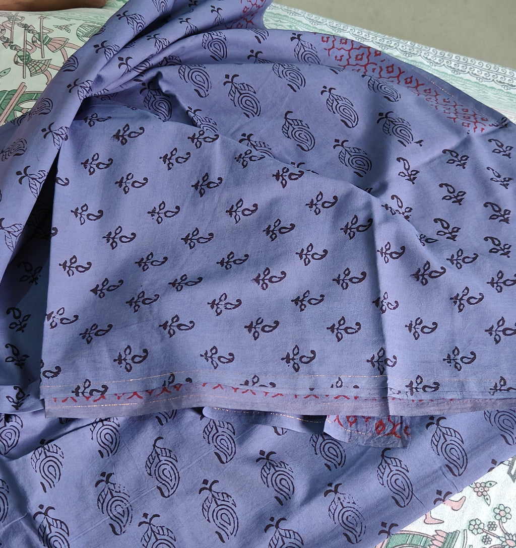 Handmade Purple fabric with Bagh print with  black patterns and silver earrings on a patterned surface