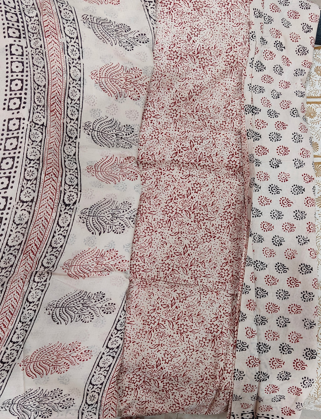 Traditional white Dhar Bagh hand block print unstitched suit set in pure cotton featuring intricate black and red handmade motifs with a matching dupatta.