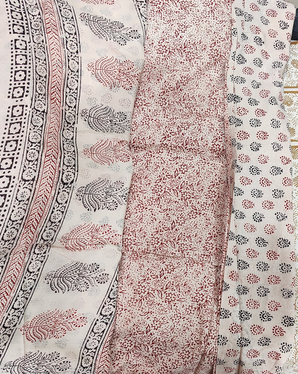 Traditional white Dhar Bagh hand block print unstitched suit set in pure cotton featuring intricate black and red handmade motifs with a matching dupatta.