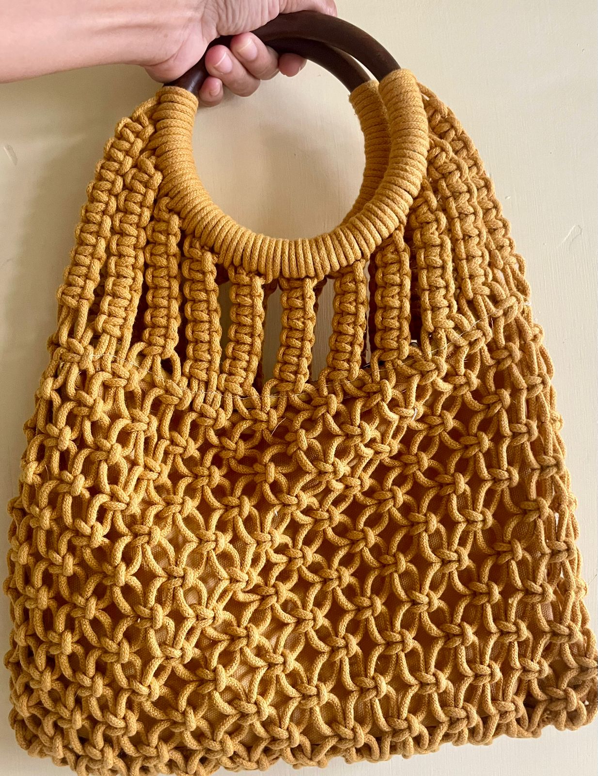 Large handmade macrame handbag in natural yellow cotton featuring sturdy wooden handles 