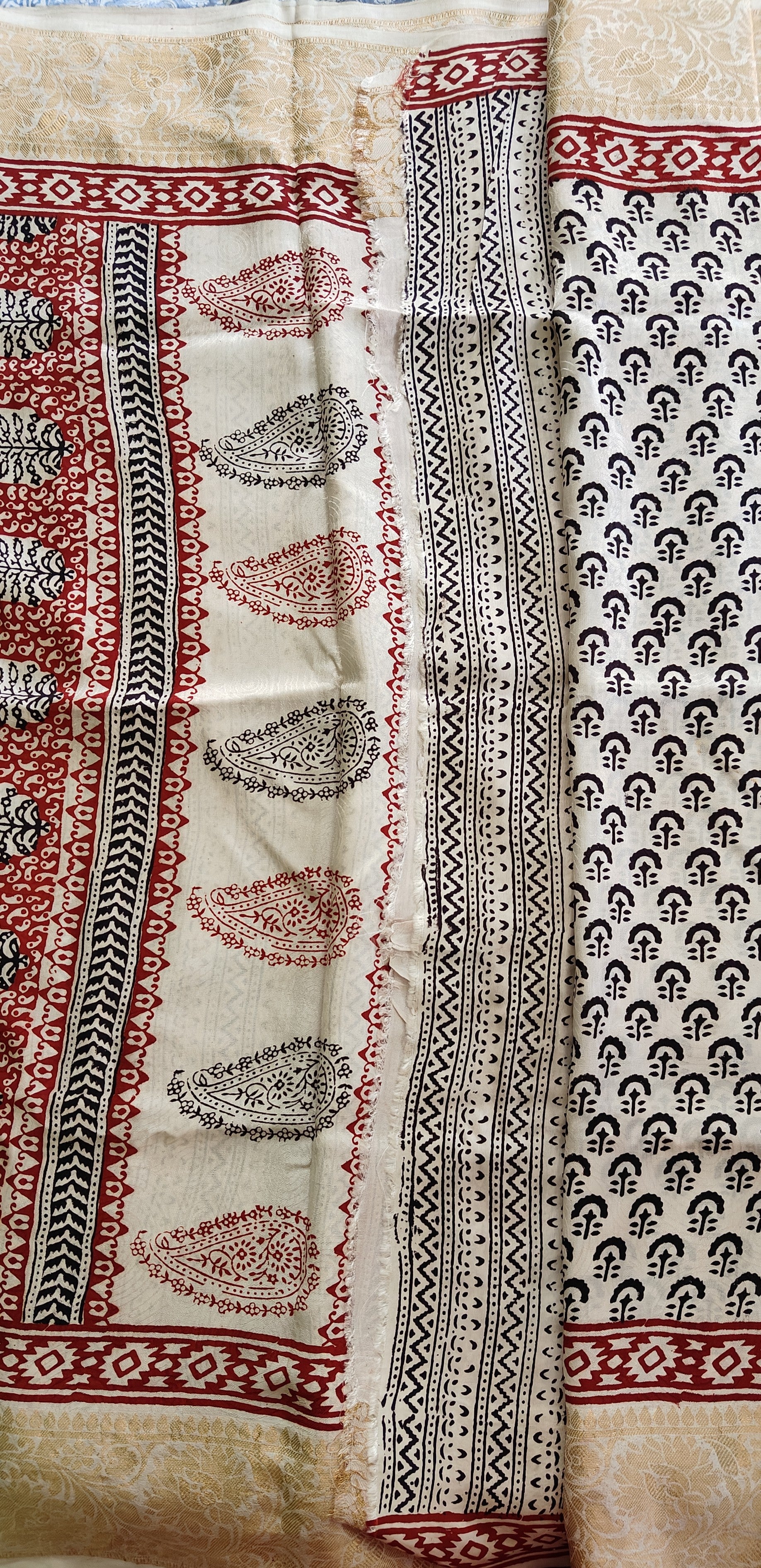 Artisan made wooden block prints on a Dola silk saree, showcasing traditional Bagh floral motifs in Back and White with red ascent