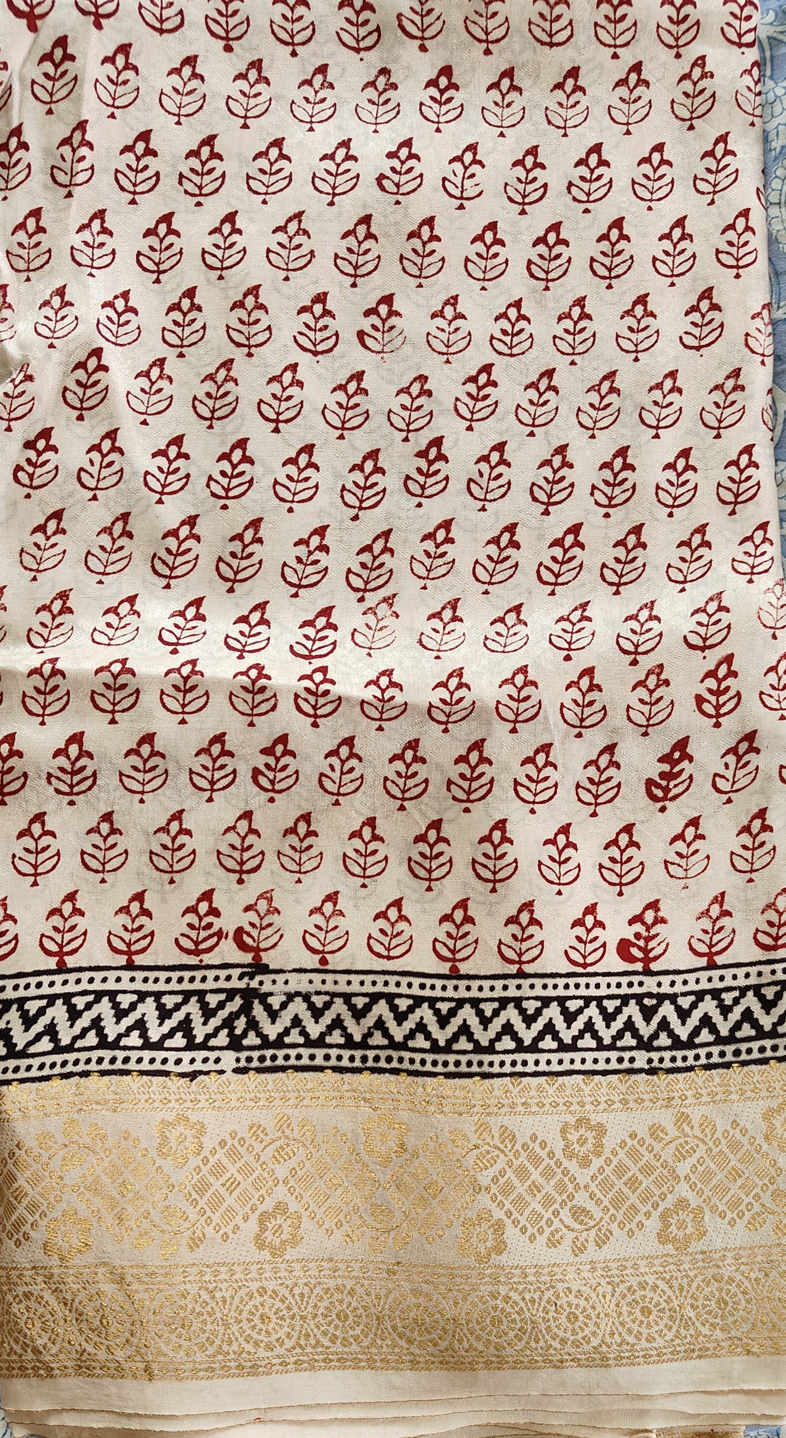 Artisan made wooden block prints on a Dola silk Saree, showcasing traditional Bagh floral motifs in red and White with red ascent