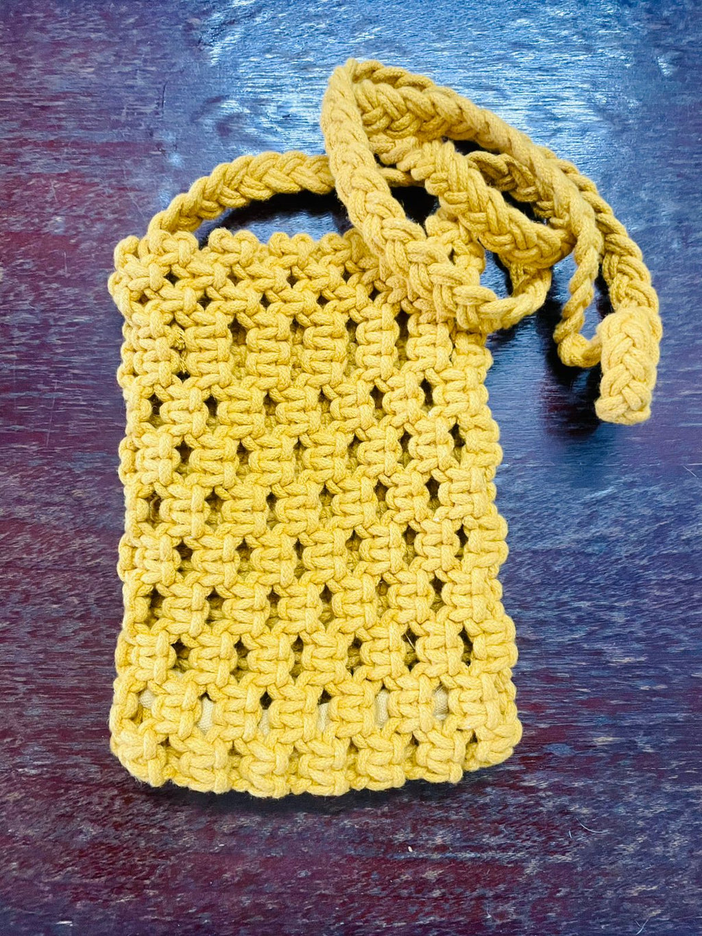 Minimalist macrame mobile sling bag with a long crossbody strap and a secure geometric knot pattern for smartphones