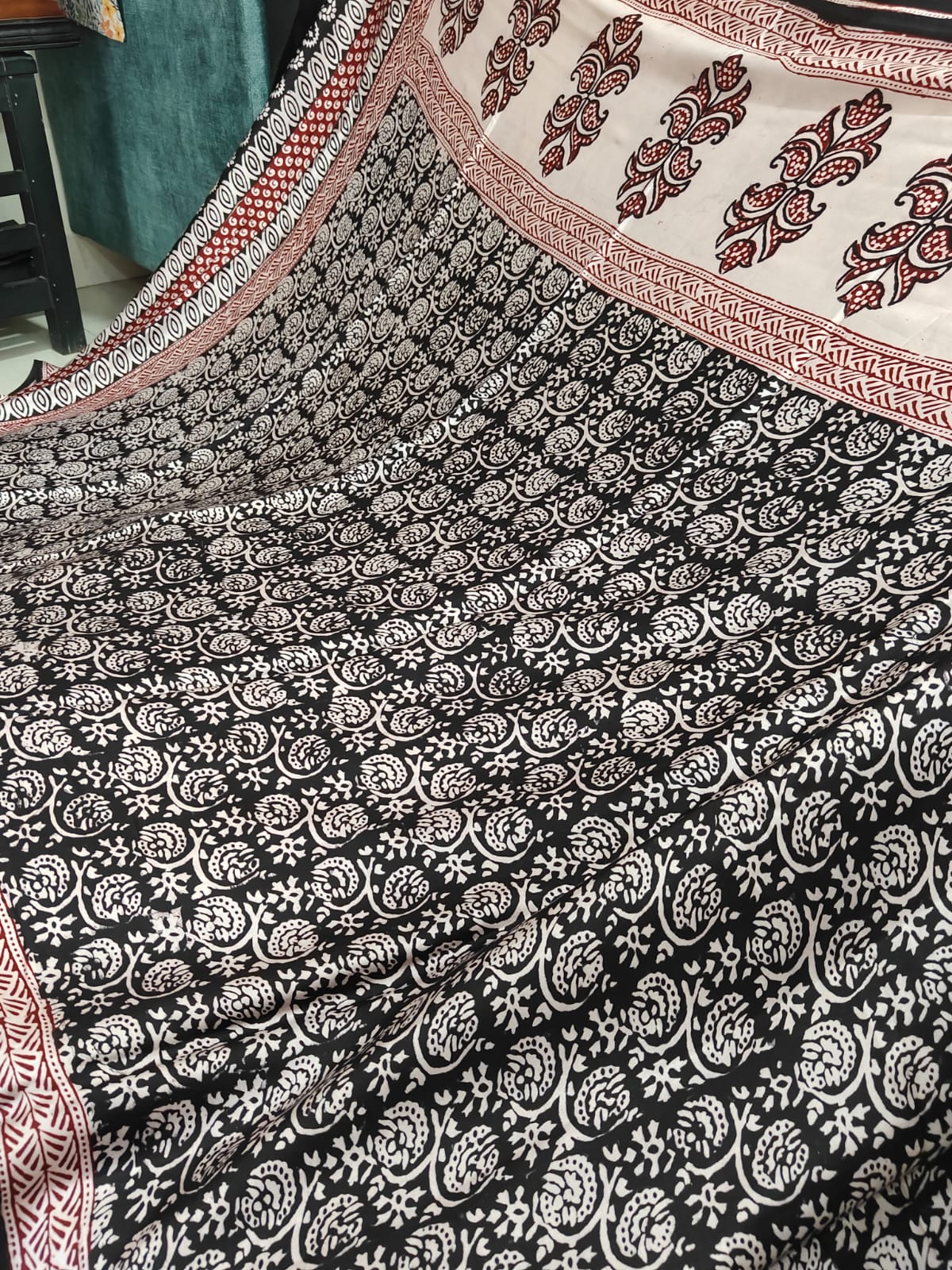 Artisan made wooden block prints on a Modal silk fabric, showcasing traditional Bagh floral motifs in Back and White with red ascent