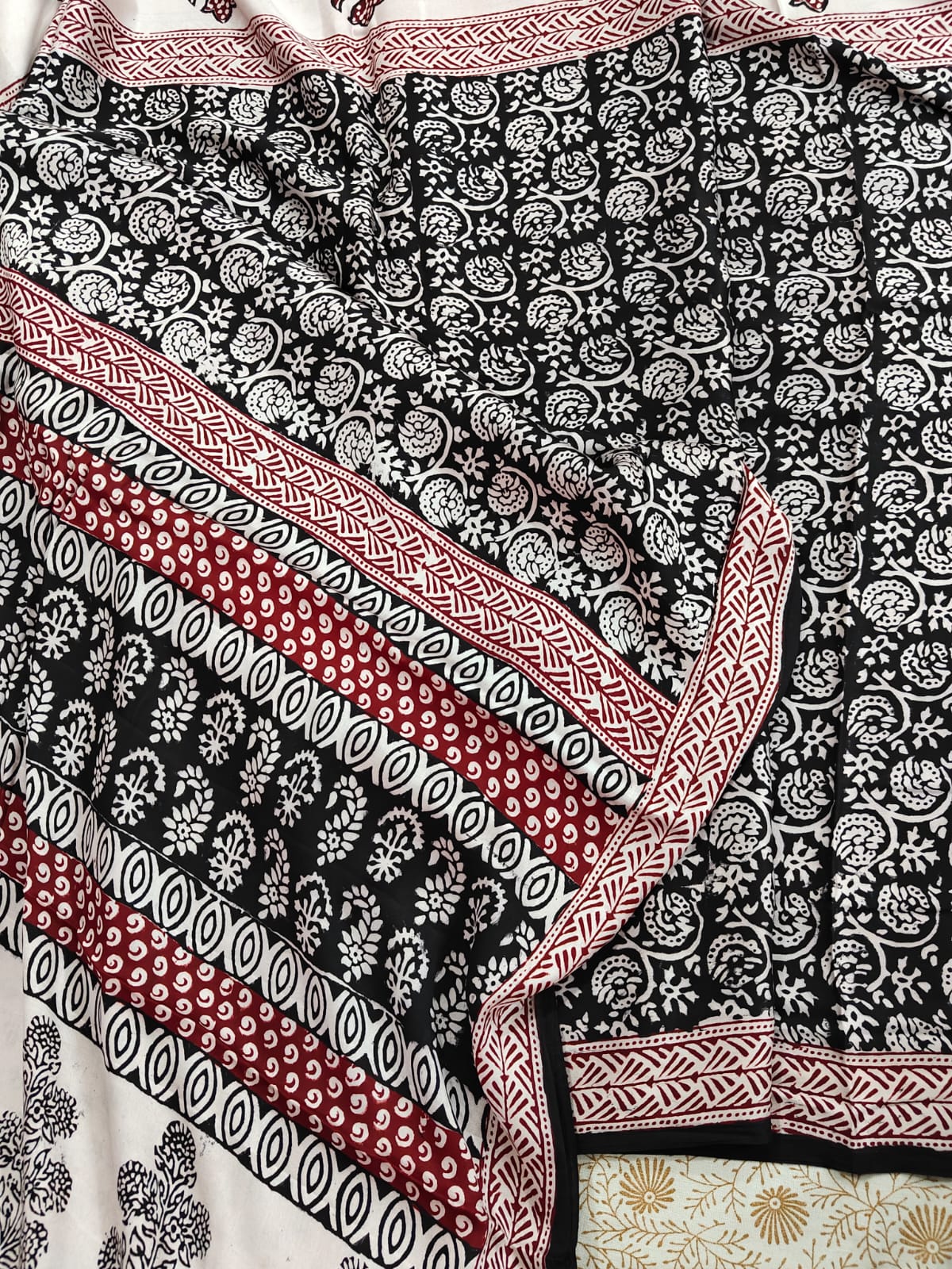 Artisan made wooden block prints on a Modal silk fabric, showcasing traditional Bagh floral motifs in Back and White with red ascent