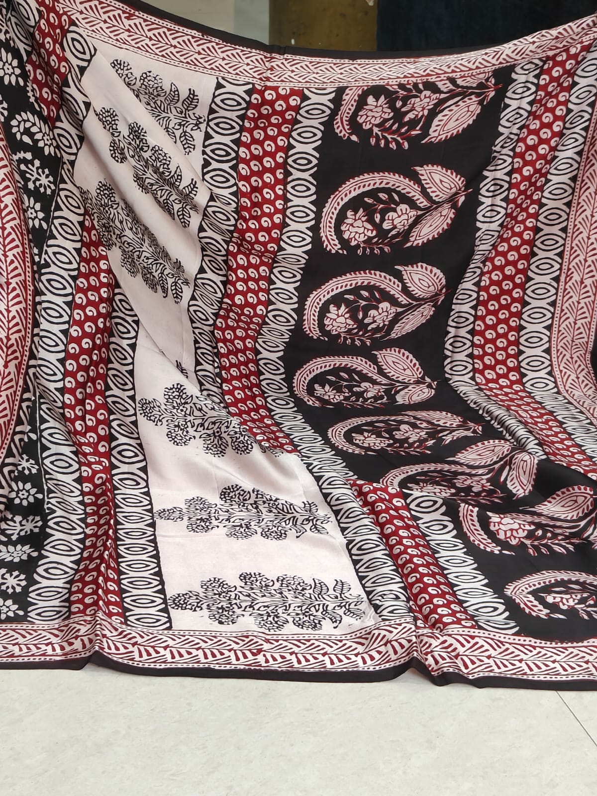 Artisan made wooden block prints on a Modal silk fabric, showcasing traditional Bagh floral motifs in Back and White with red ascent