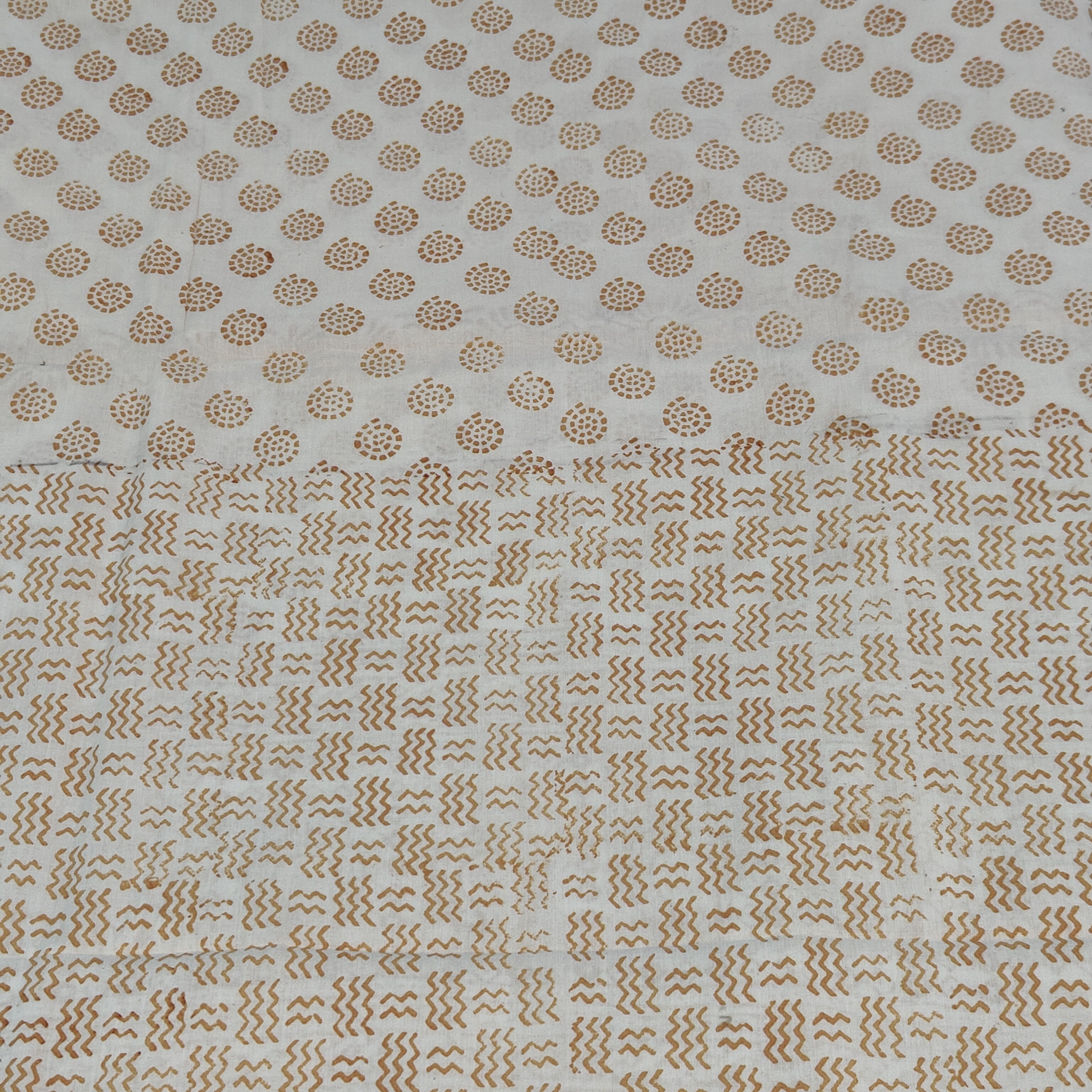 Traditional Dhar Bagh block print on off-white pure cotton fabric; copper-colored handmade circular  motifs on an unstitched suit set with dupatta