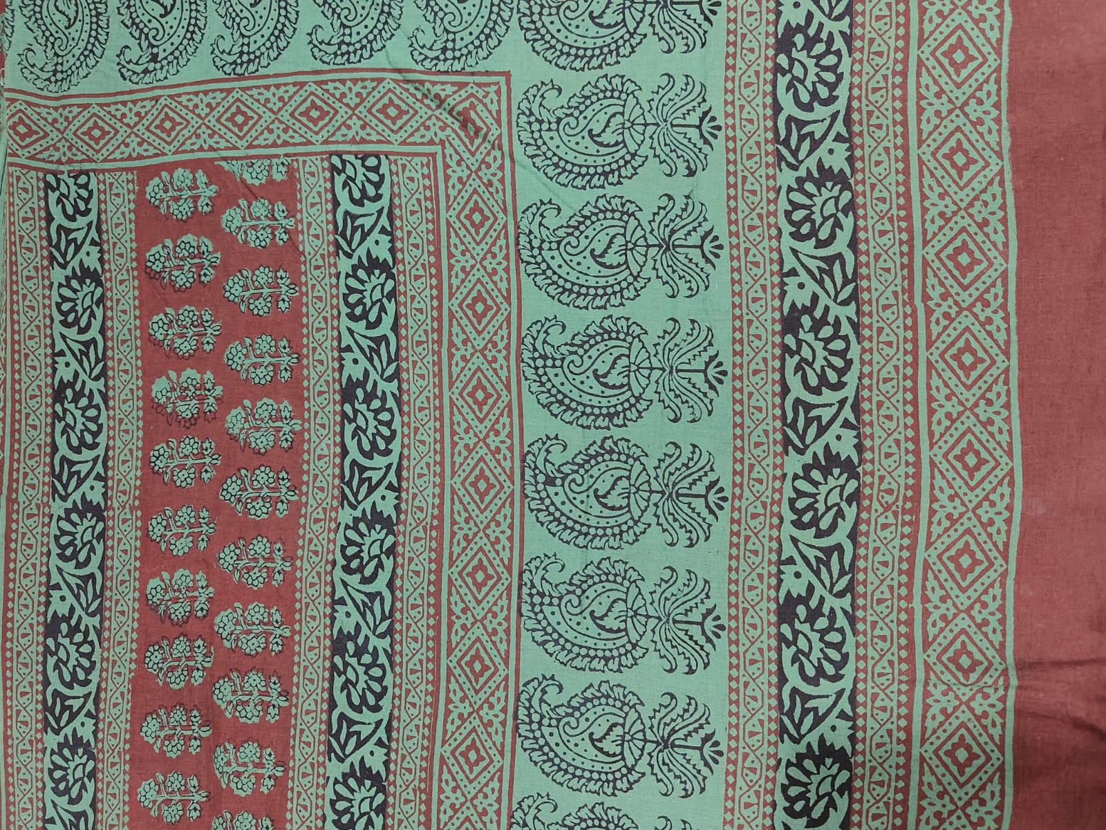 Bagh Block handmade cotton fabric for suite with green design on a red background