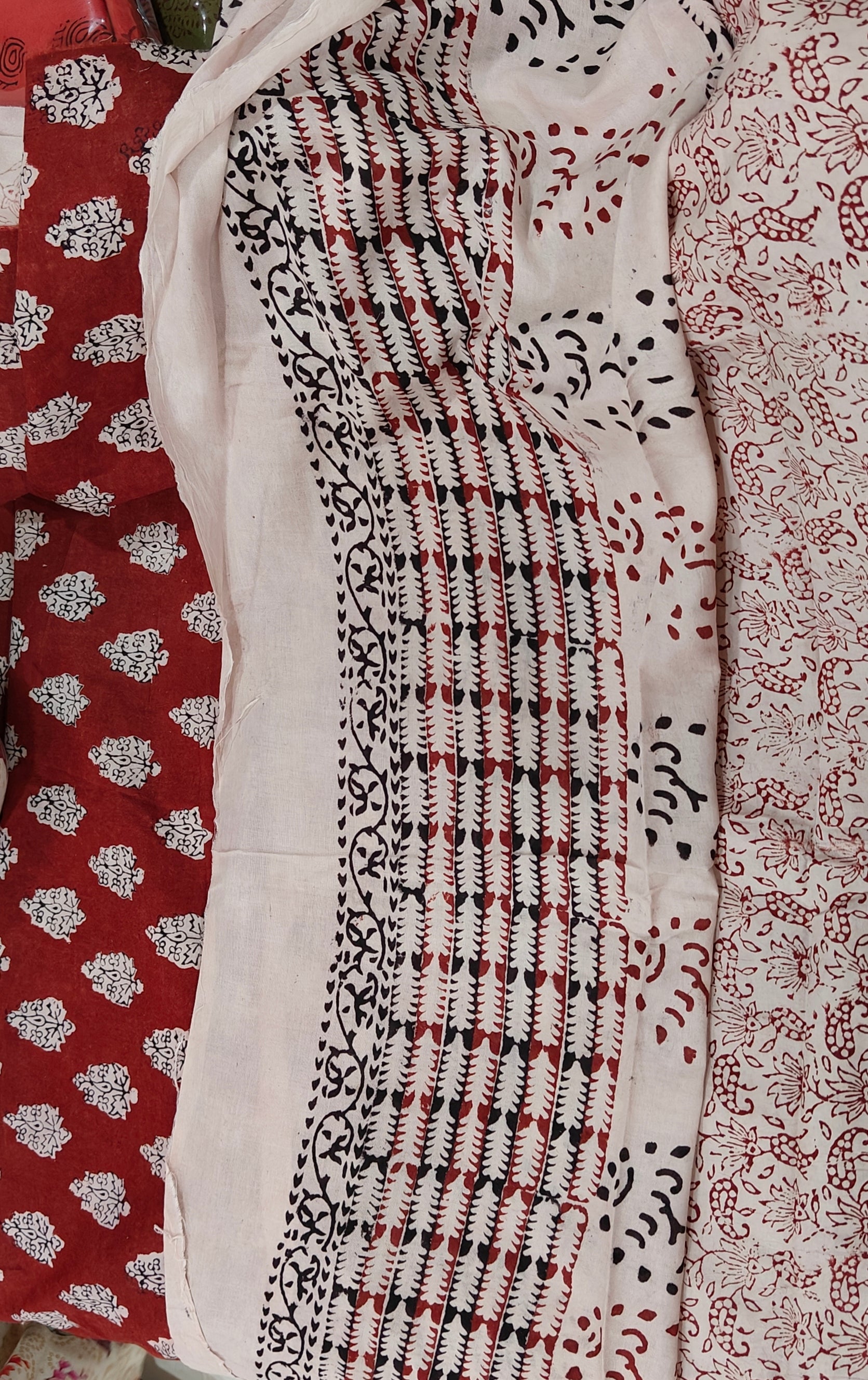 Artisan made wooden block prints on a pure cotton suite material, showcasing traditional Bagh floral motifs in red and White with black ascent