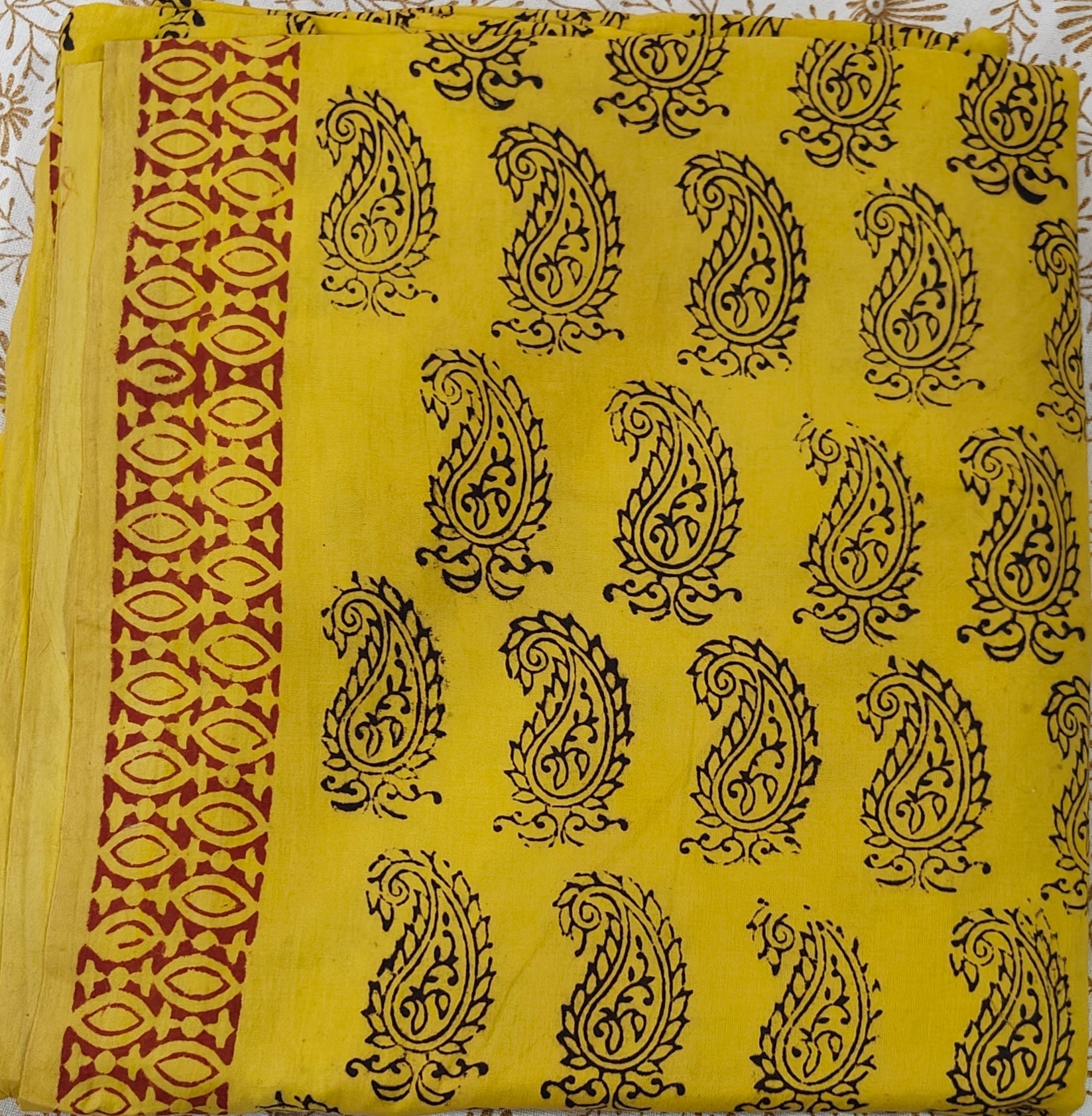 Traditional yellow and maroon Dhar Bagh hand block print unstitched suit set in pure cotton with handmade motifs and matching dupatta.